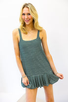 Woman wearing a green and white striped dress on a white background