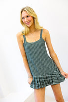 Woman wearing a green and white striped dress against a white background