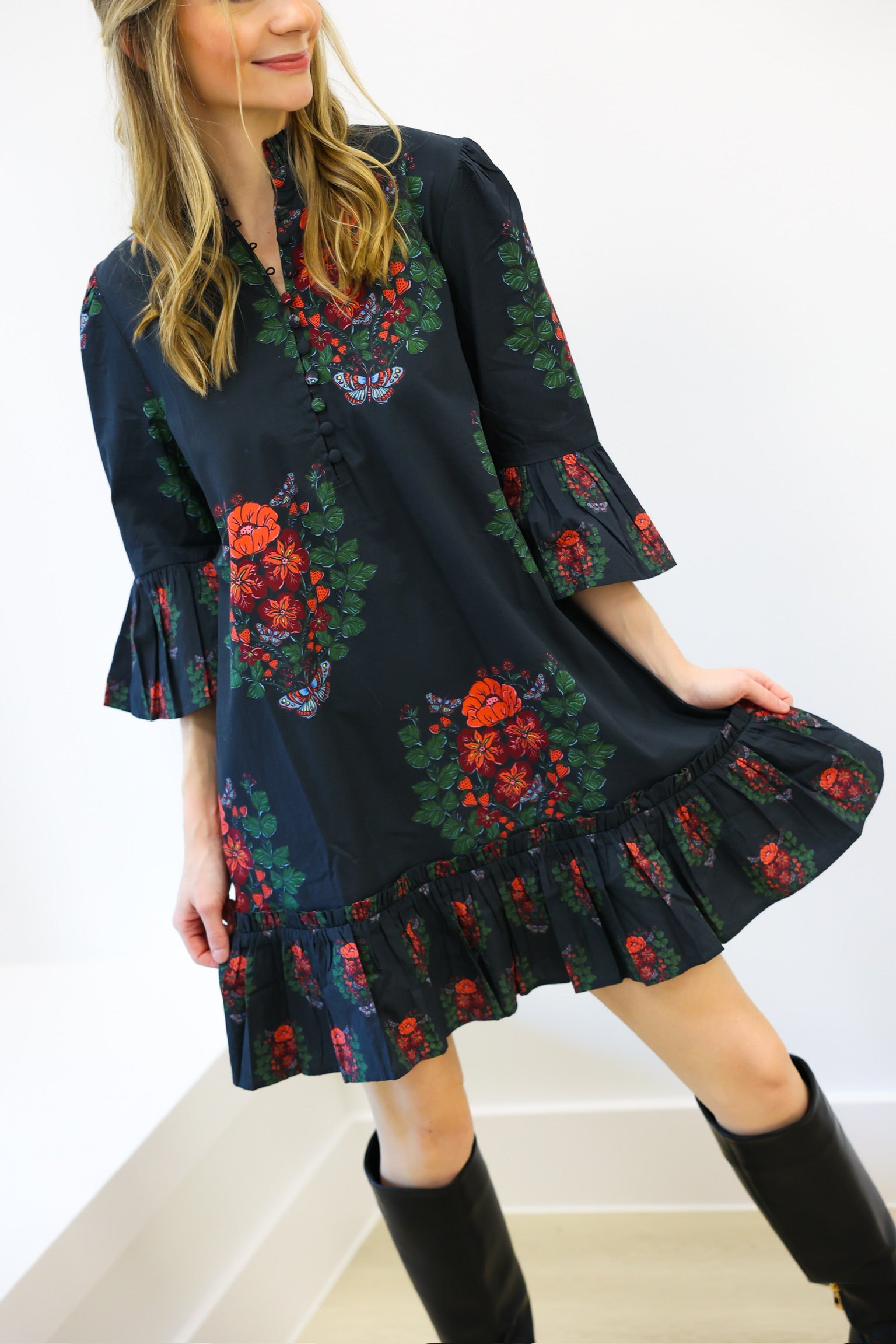 Woman wearing a dark floral dress with a white background