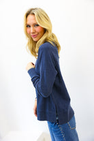Woman wearing a blue sweater and jeans on a white background