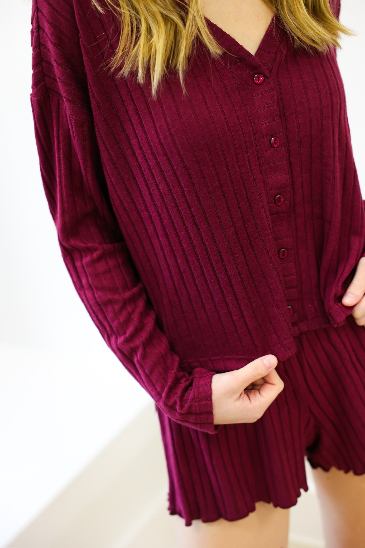 Maroon ribbed long-sleeve top and shorts set on a white background
