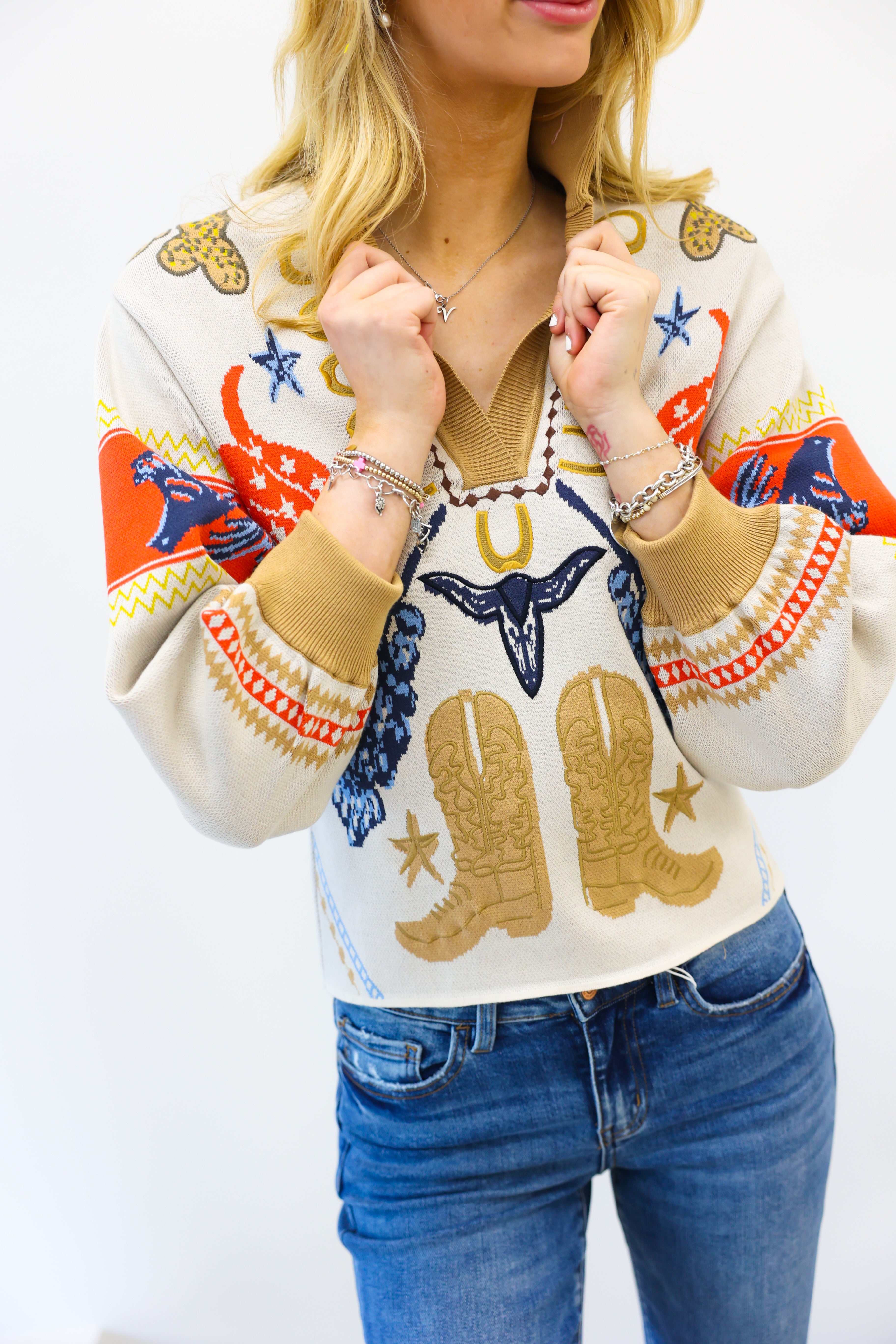 Woman wearing a colorful sweater with cowboy boot designs on a white background