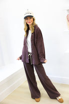 Woman wearing a brown tracksuit and cap indoors