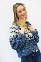 Woman wearing a blue patterned sweater against a white background
