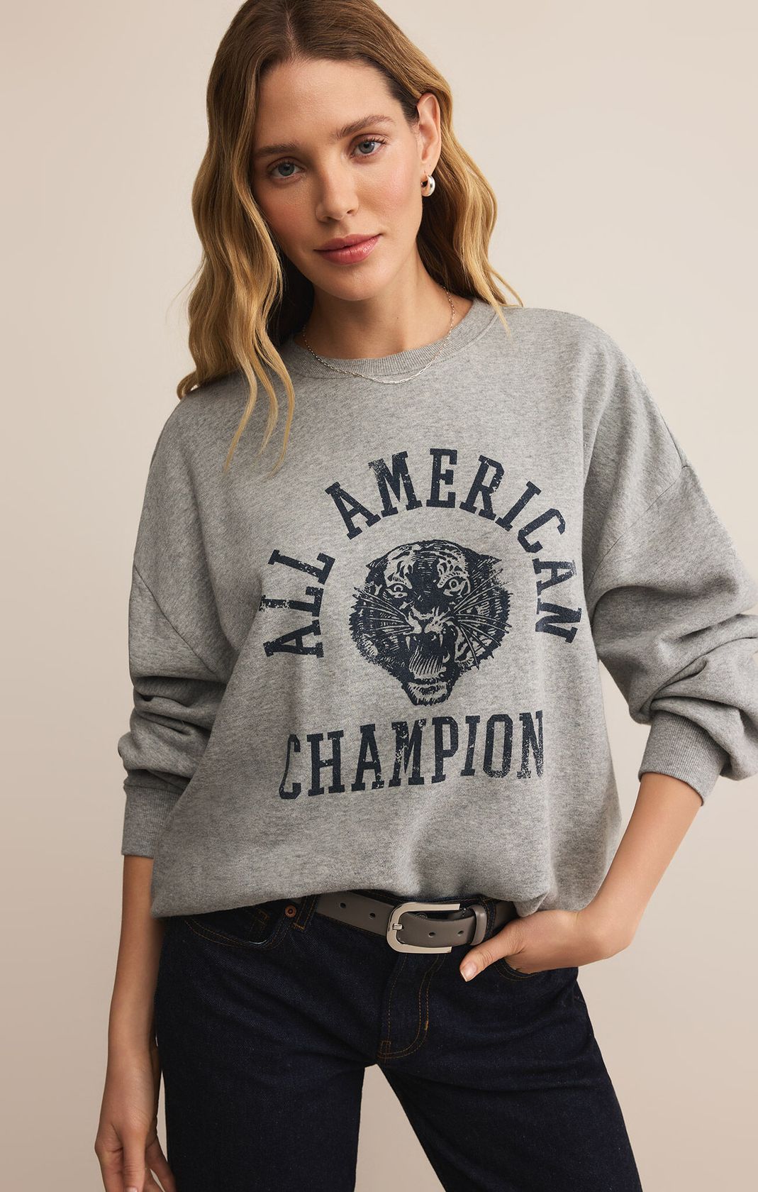 Woman wearing a gray sweatshirt with 'All American Champion' text and tiger graphic.