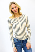 Woman wearing a striped long-sleeve top and jeans on a white background