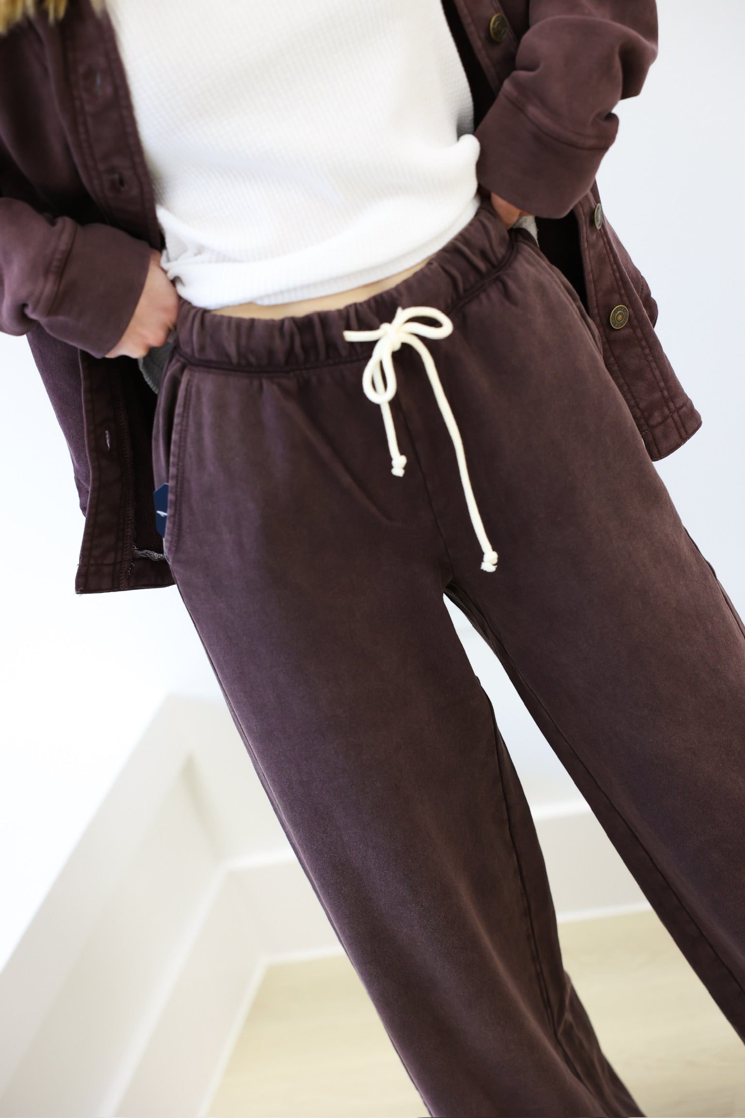 Brown corduroy pants with a white shirt and jacket on a white background