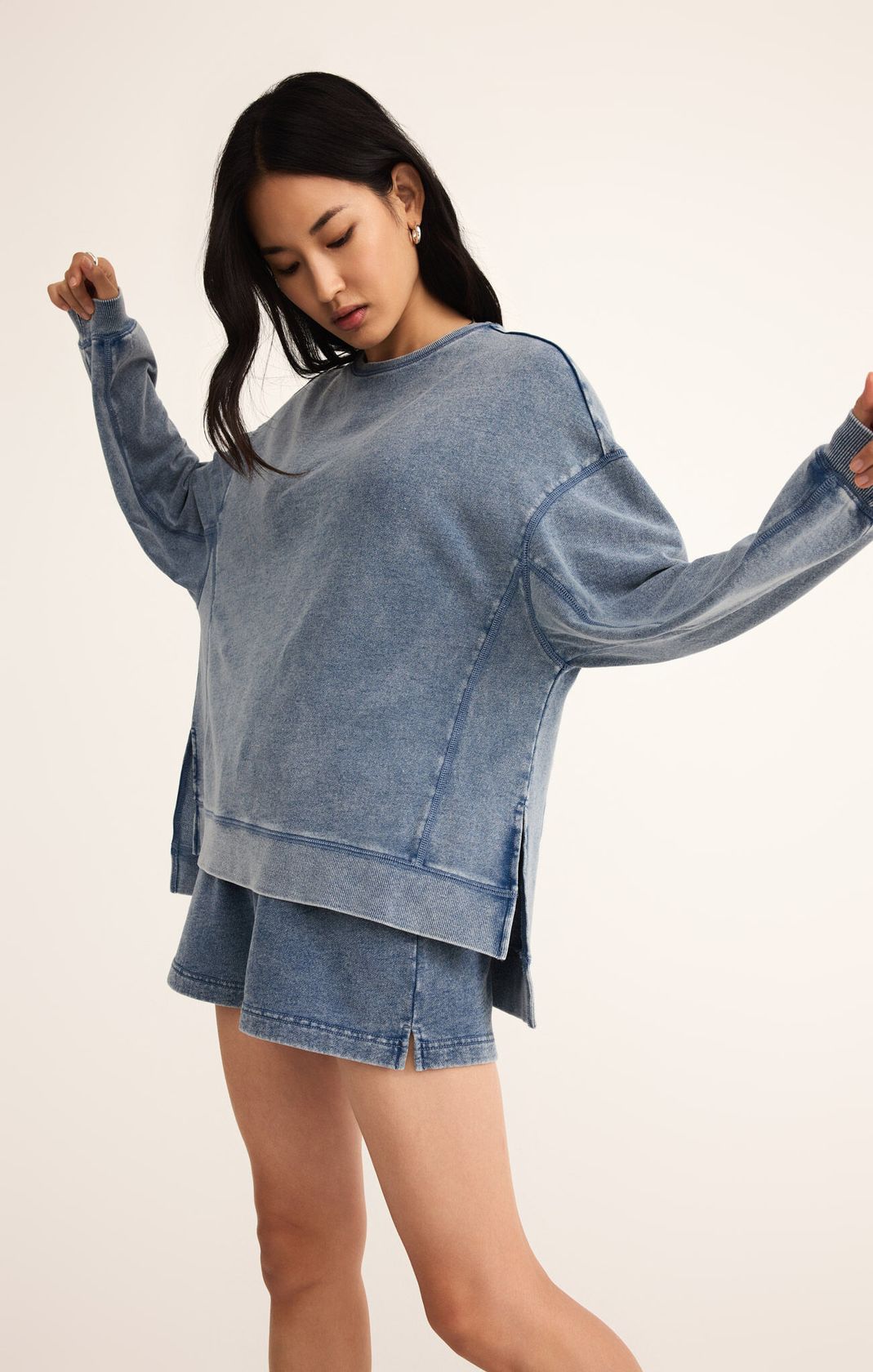 Woman wearing a blue denim outfit on a plain background