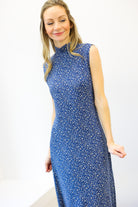 Woman wearing a blue floral dress against a white background