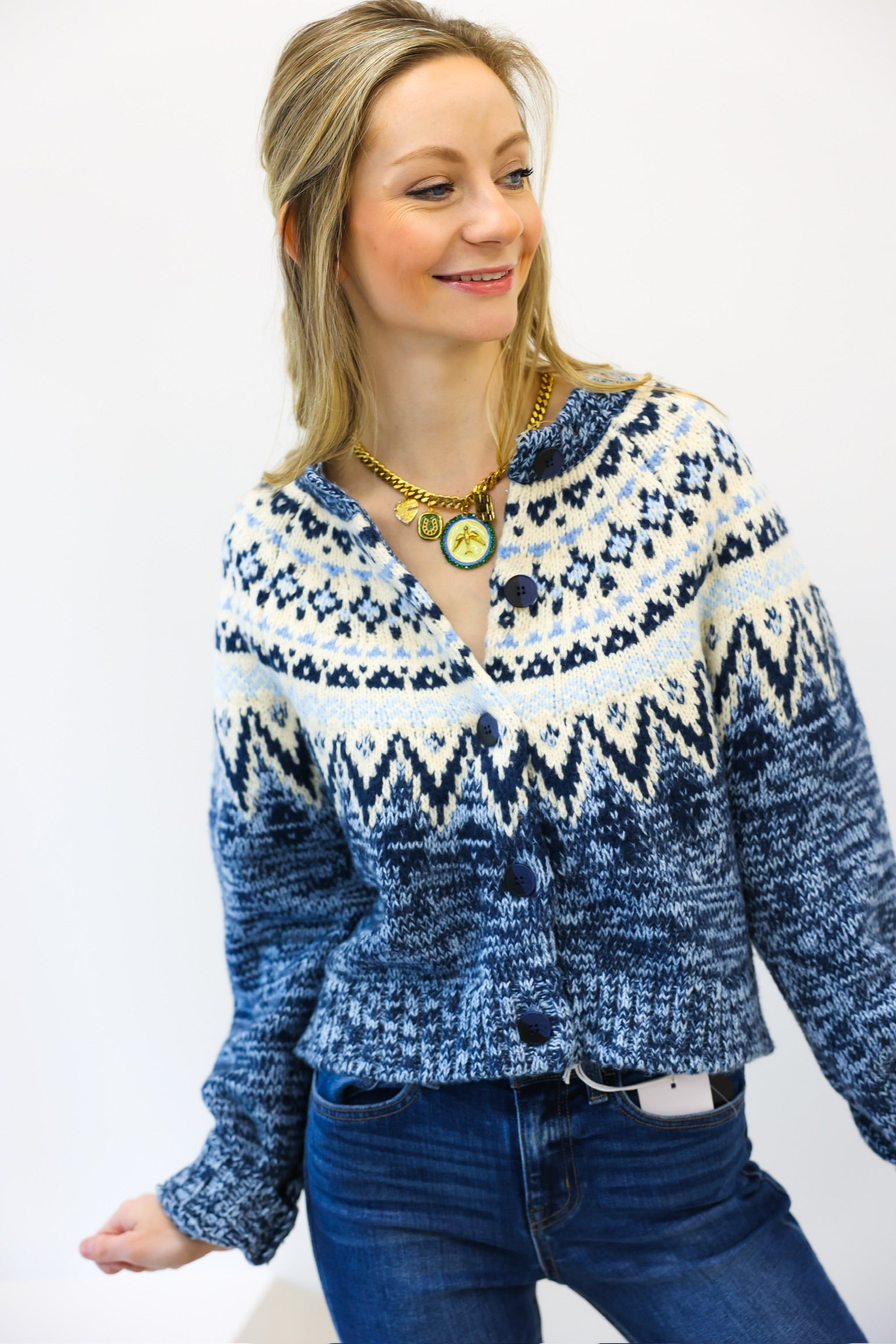 Woman wearing a blue and white patterned sweater against a white background
