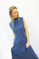 Woman wearing a blue floral dress against a white background