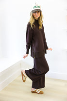 Person wearing a brown outfit with a cap indoors